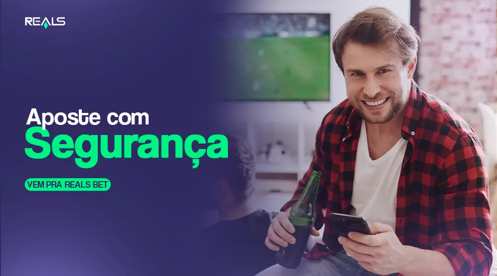 homem sorrindo com uma cerveja em uma mão e o celular na outra, enquanto na televisão ao fundo é transmitido um jogo de futebol. Na arte aparece um texto incentivando apostas com segurança na reals bet Brasil